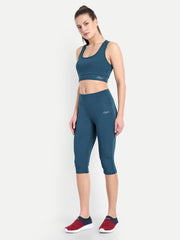 Model confidently posing in Waylene's teal blue capri and sports bra set, highlighting the side stitching and snug fit, perfect for gym workouts and yoga sessions.