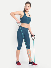 Waylene's teal blue capri and sports bra set for yoga and gym, featuring a model using resistance bands in a standing pose, showcasing the flexibility and fit of the activewear.