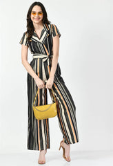 Waylene's multi-color striped jumpsuit with a collared neckline and matching belt, accessorized with yellow handbag and sunglasses. Model poses with one hand on hip on a white backdrop.