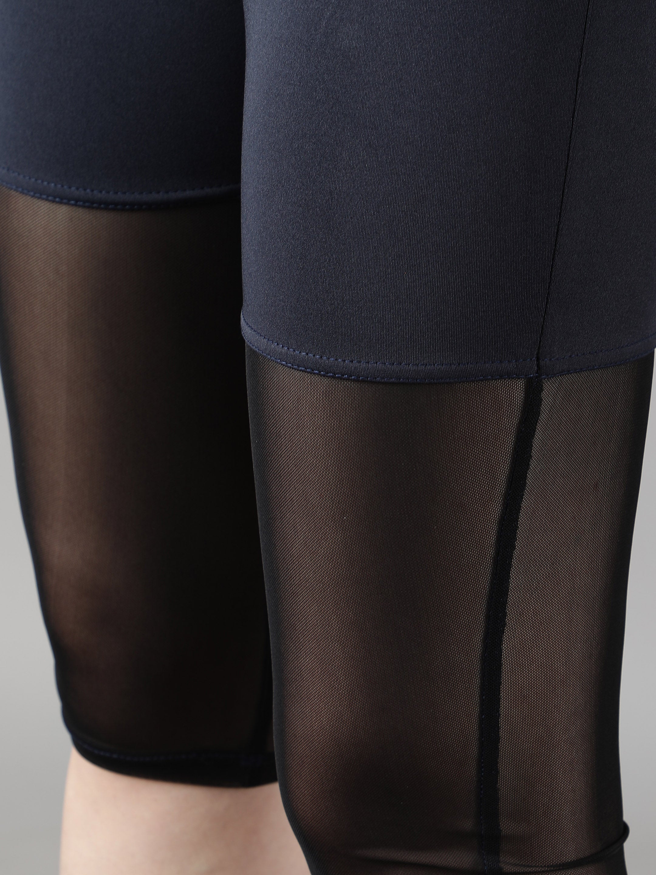 Detailed close-up of Waylene's navy blue capri tights with mesh panels, focusing on the fabric quality and stitching, perfect for active wear.