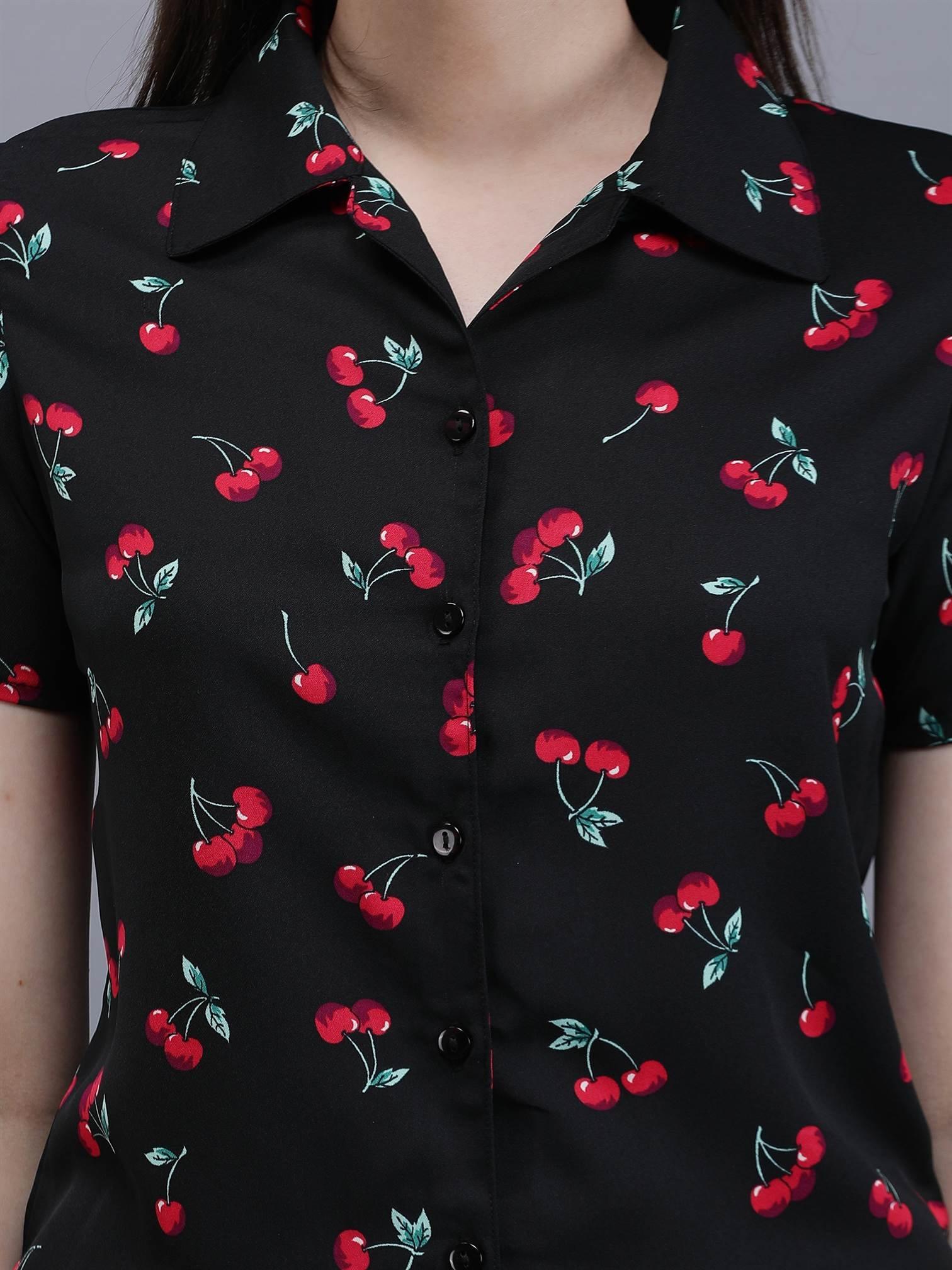 Close-up of Waylene cherry print and button-up detail on black shirt.